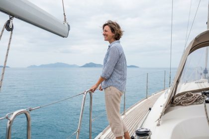 Femme naviguant sur un voilier en mer sous un ciel ensoleillé